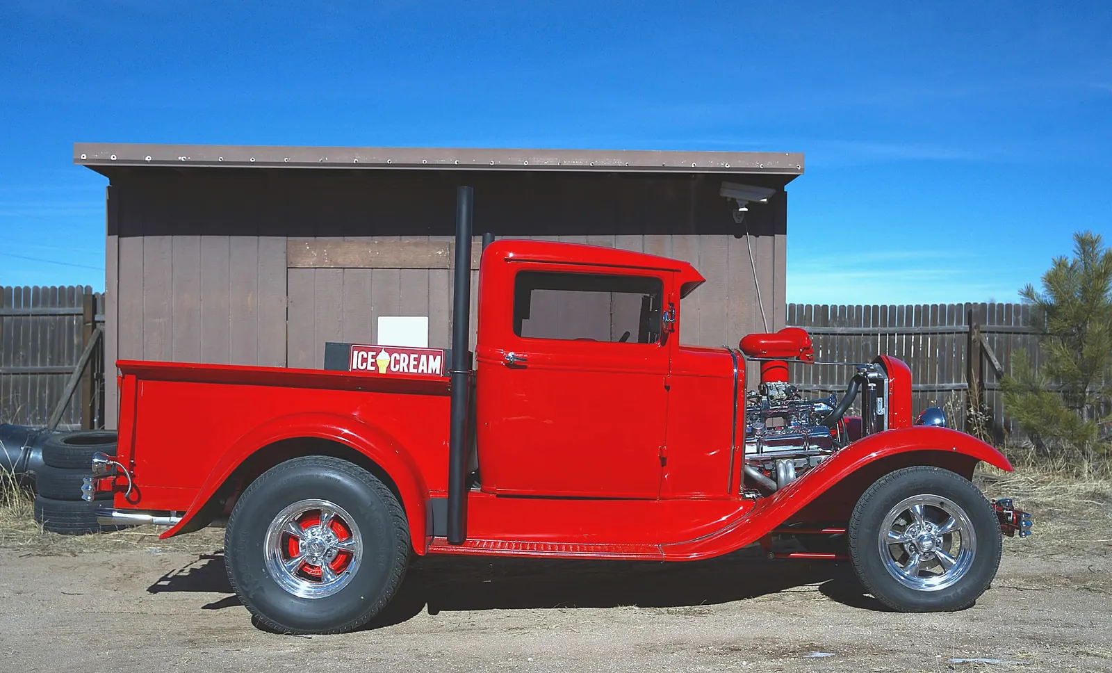 Red 1930s Ford Model A hot rod pickup truck with a custom V8 engine