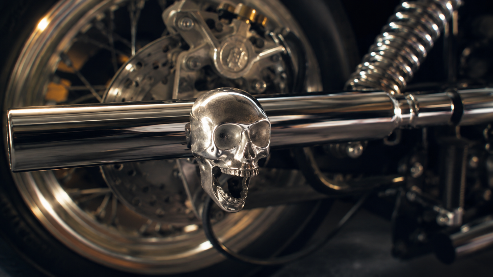 Polished cast-metal universal skull mounted on a motorcycle chrome bar, shown in a moody cinematic close-up with spokes, suspension, and chrome details in the b